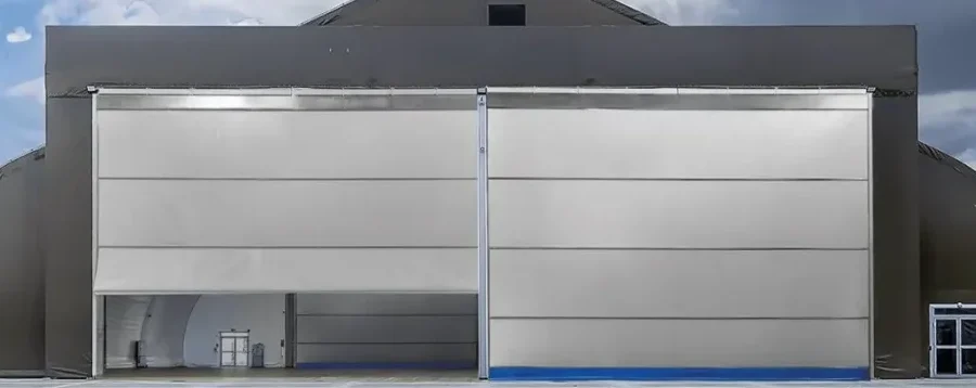 Podwójna brama materiałowa na hangarze pod dramatycznym niebem